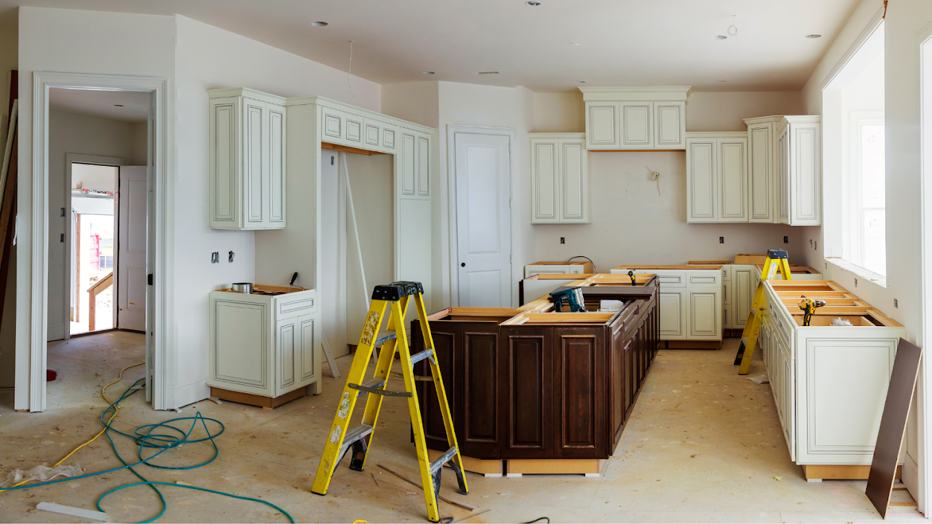 Kitchen in progress with cabinets installed and ladders on site.